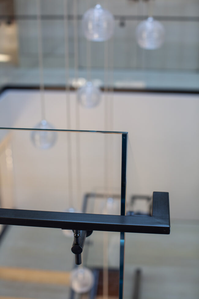 A glass table with a metal frame and some lights hanging from it