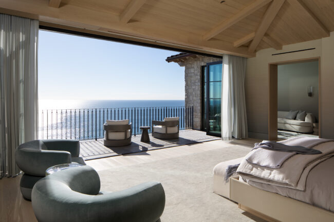 A room with a view of the ocean and a balcony.