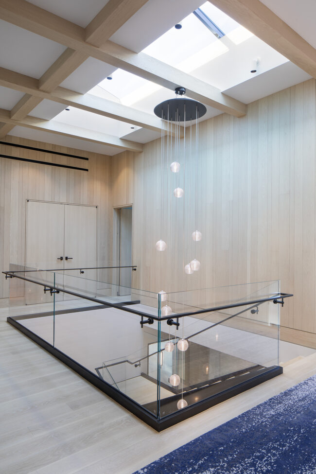 A glass table with a shower head hanging above it.