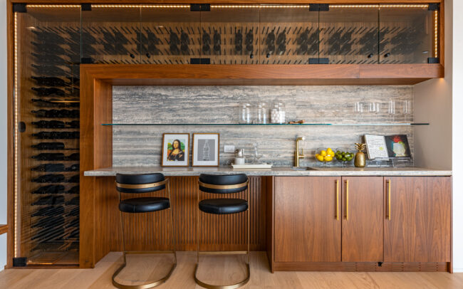 A kitchen with wooden cabinets and black stools.