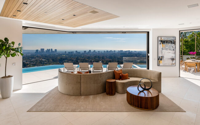 A living room with a large window and a view of the city.