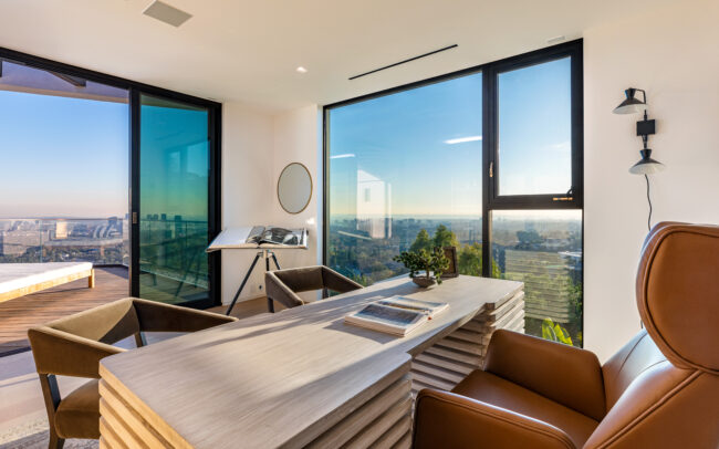 A room with large windows and a view of the city.