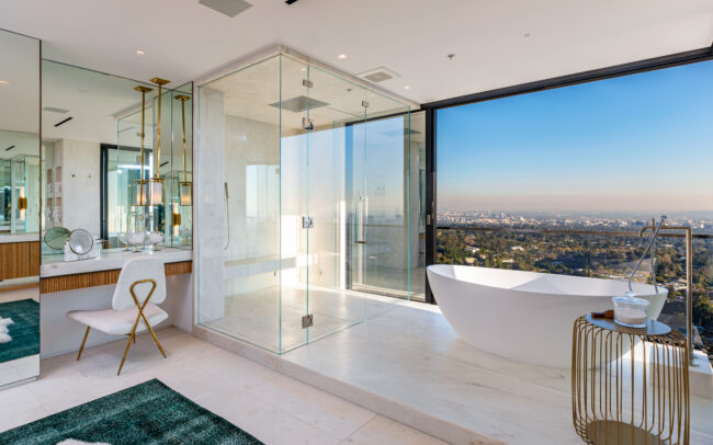 A bathroom with a large glass shower and a bathtub.