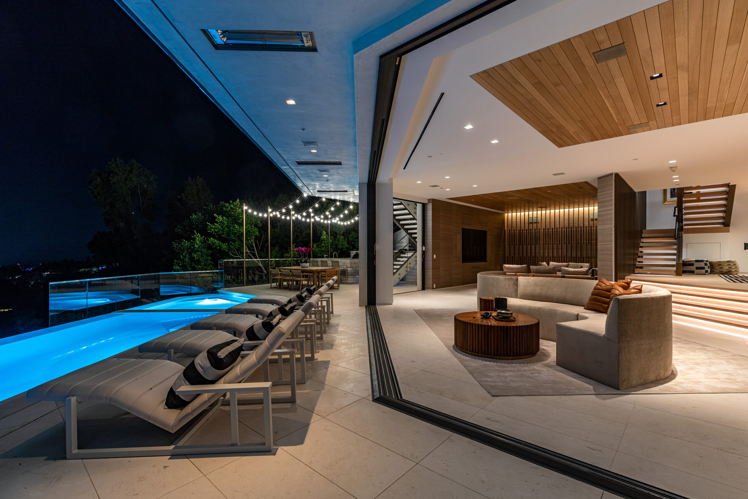 A pool and lounge chairs in the middle of an indoor living room.