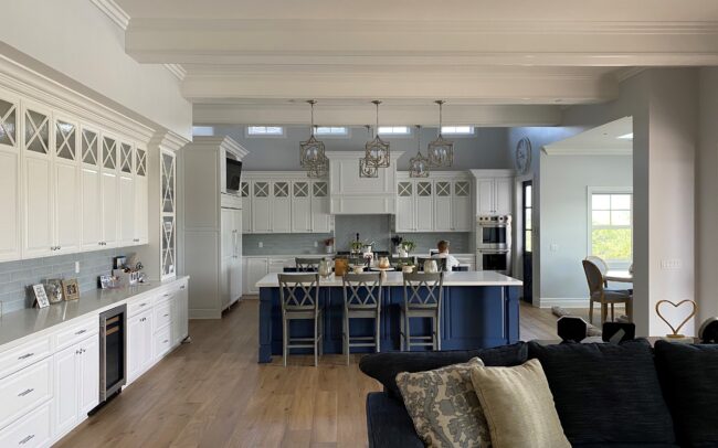 A large open kitchen with white cabinets and blue island.