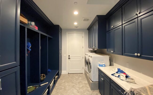 A room with blue cabinets and white counters.
