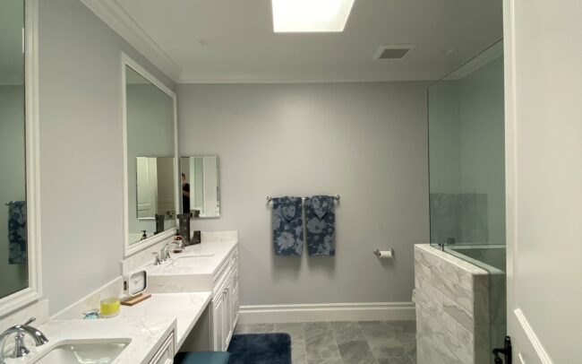 A bathroom with two sinks and a mirror.