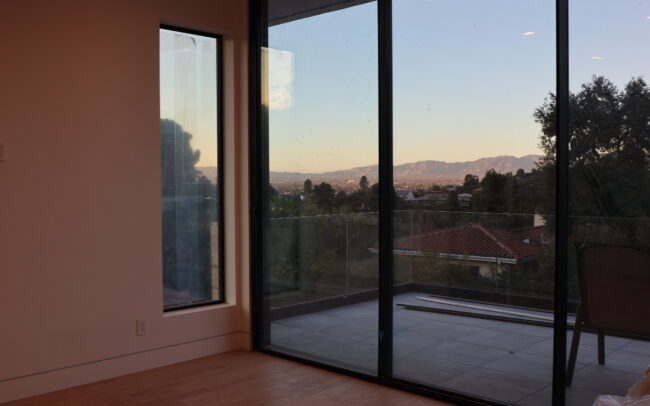 A bedroom with sliding glass doors and a view of the mountains.