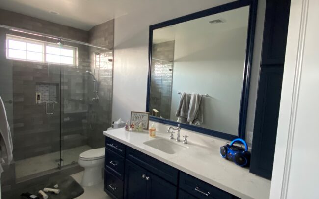 A bathroom with a large mirror and a sink.