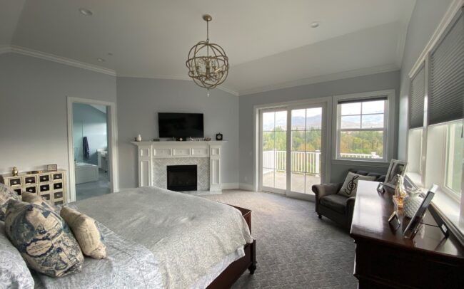 A bedroom with a fireplace and a large bed