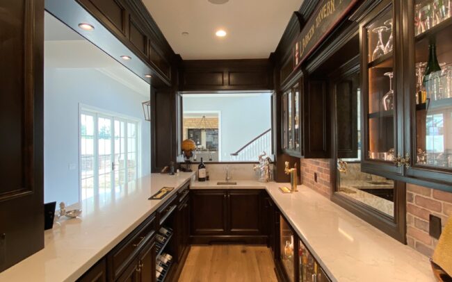 A kitchen with dark wood cabinets and white counters.