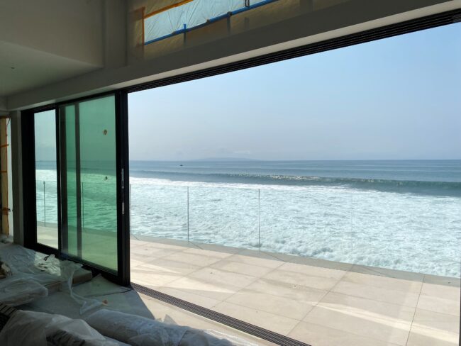 A large window overlooking the ocean from an outside room.