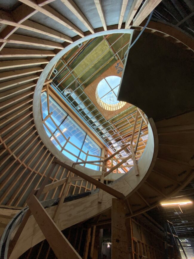 A spiral staircase with wooden steps and a glass ceiling.