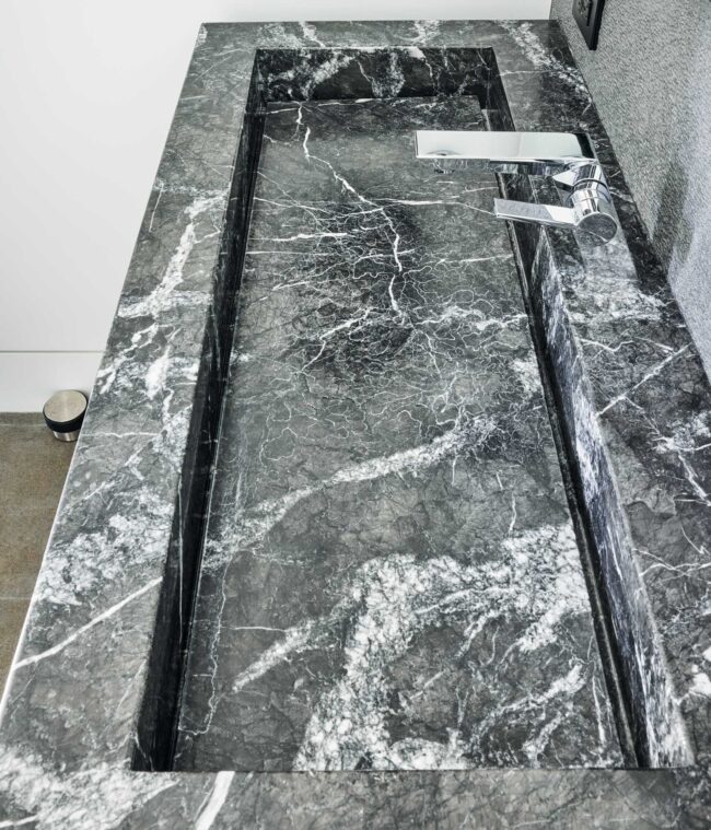 A marble slab with a metal rail on top of it.