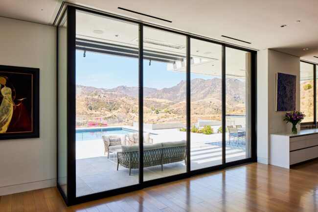 A large sliding glass door with a view of the mountains.