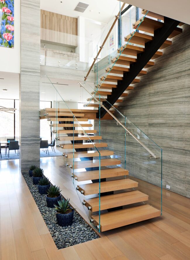 A wooden staircase with glass railings and wood steps.