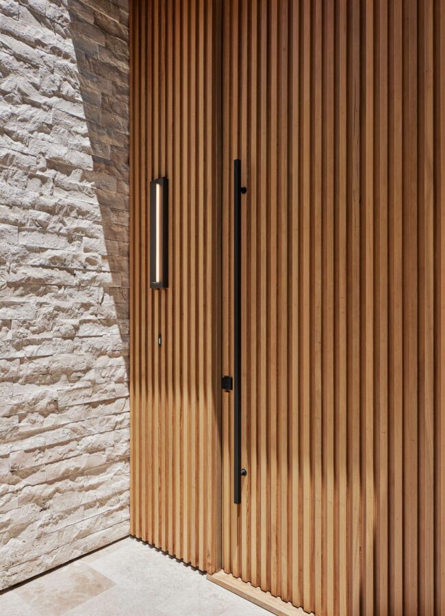 A close up of the door handle on a wooden door.