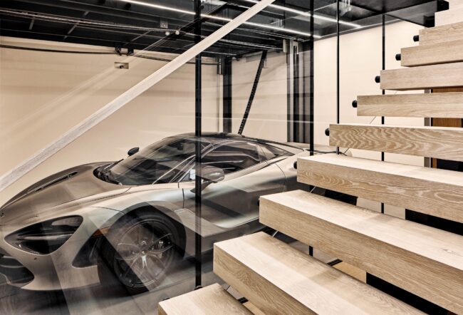 A car is parked inside of a building with stairs.