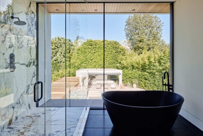 A bathroom with a tub and a large window.