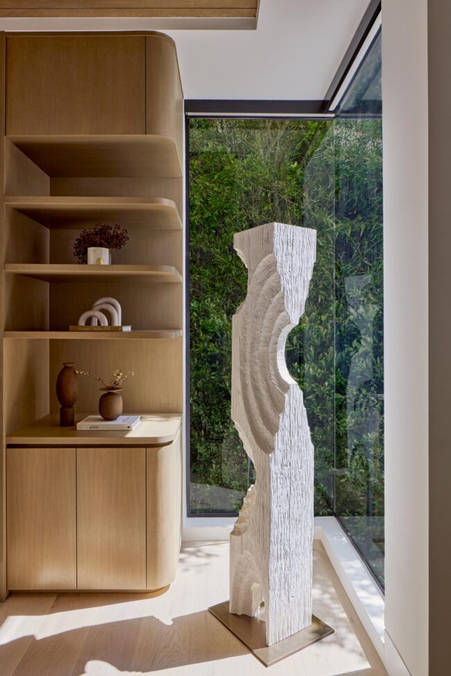 A white marble sculpture in front of a window.