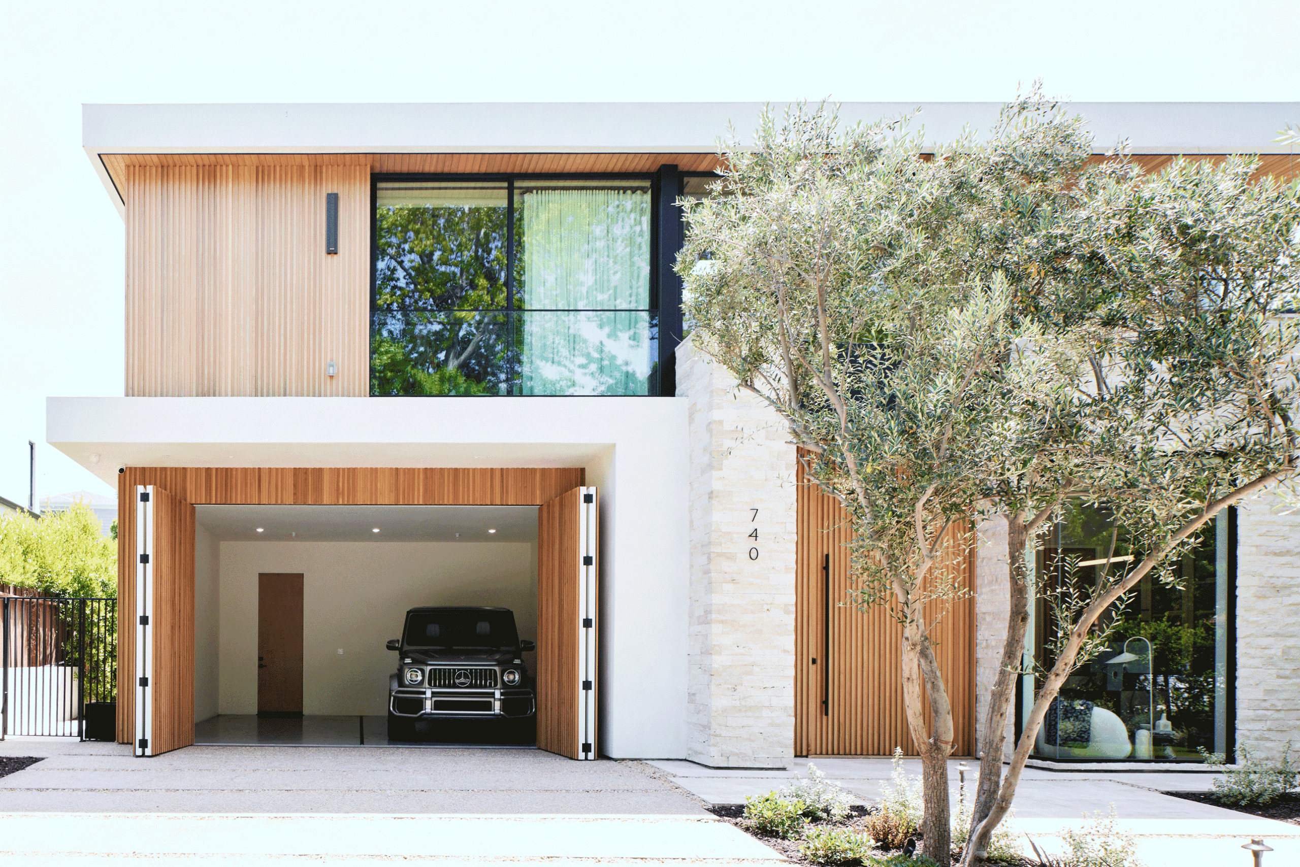 A car is parked in the garage of this modern house.