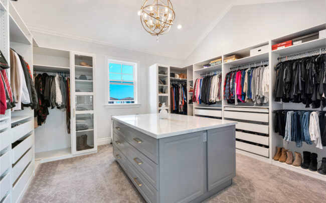 A large walk in closet with lots of clothes.